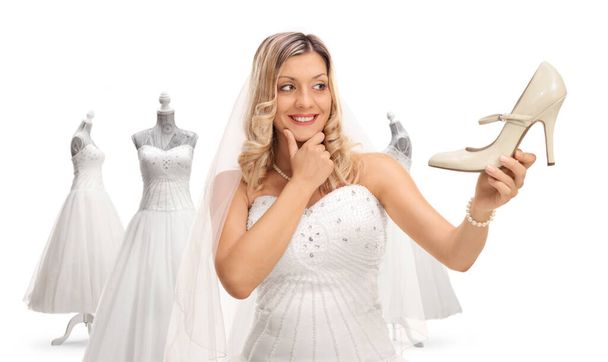 Bride choosing shoes and a dress for her wedding isolated on white background - Fotó, kép