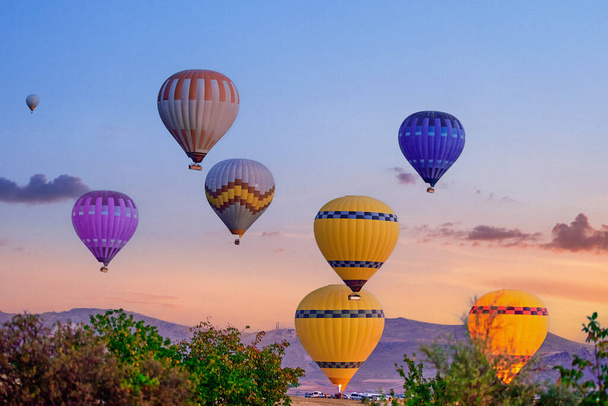 Landscape of colorful flying hot air balloons in Anatolia, Kapadokya at sunrise. National park in Nevsehir, Goreme - Photo, image