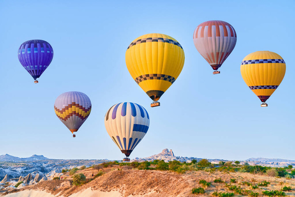 Landscape of colorful flying hot air balloons in Anatolia, Kapadokya at sunrise. National park in Nevsehir, Goreme - Photo, image