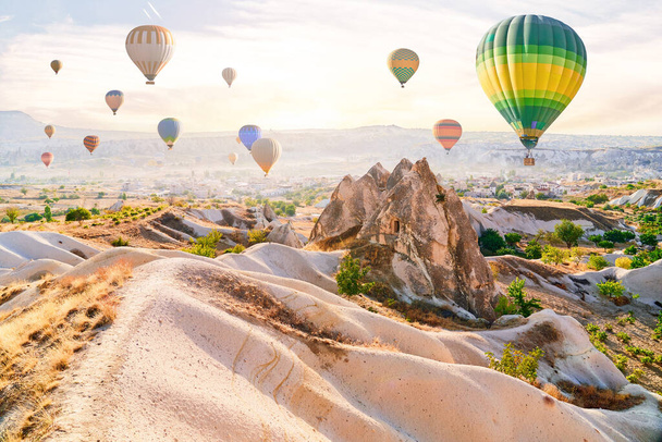 Landscape of scenic valley with colorful flying hot air balloons in Anatolia, Kapadokya. Beautiful destination in Nevsehir, Goreme - Foto, immagini