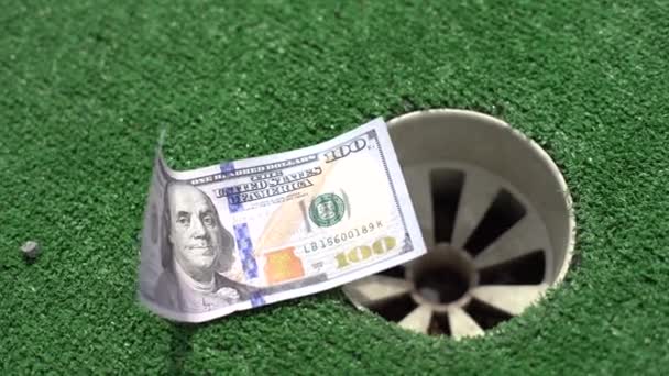 Tiempo para jugar al golf, dinero en el mini hoyo de golf. - Imágenes, Vídeo