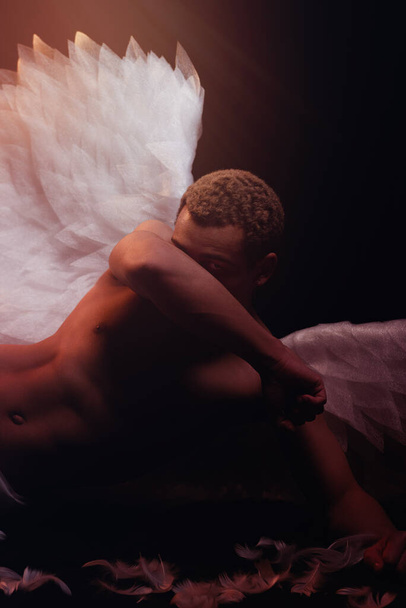 Young strong angel with white wings from heaven. Angel with muscular body. Sensual man - 写真・画像