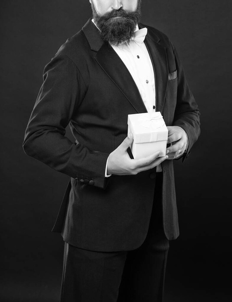 cropped man in tuxedo bow tie formalwear on black background hold box. shopping sale. - Fotoğraf, Görsel