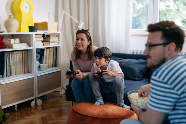Mother and son play the video game together at home - Фото, изображение