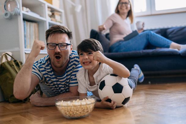 Happy football fans are cheering while watching the game. family time. - Φωτογραφία, εικόνα