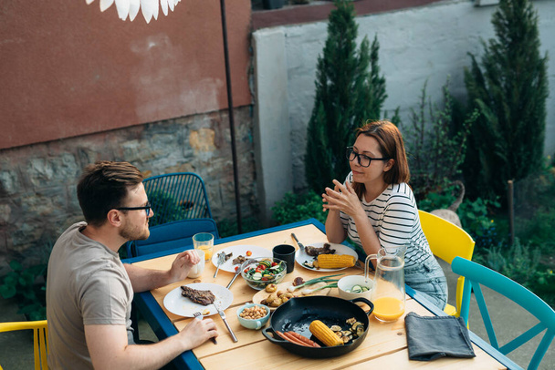 Husband and wife have lunch together in the backyard - Photo, image