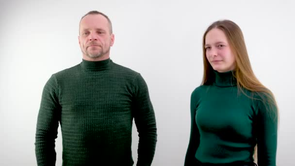 um homem e uma mulher em roupas verdes em um fundo branco olhar entrevista conversa pessoas sérias chefes professor subordinado e estudante pai e filha um par de idades diferentes - Filmagem, Vídeo