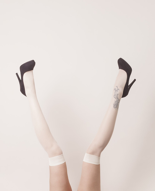Female legs up in the air wearing stockings and heels - Photo, Image