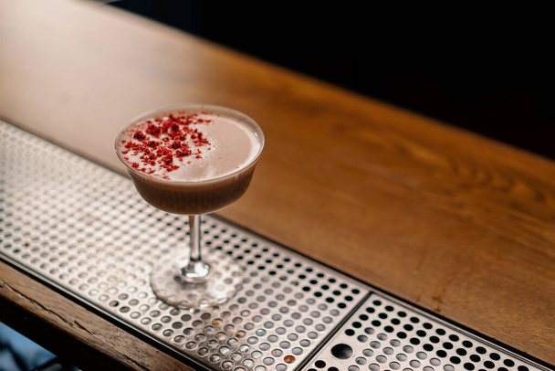 herkullinen vaaleanpunainen vastavalmisteltu mustikkakerho cocktail vadelmilla seisoo baarissa odottamassa vierasta - Valokuva, kuva