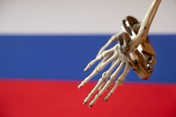 Skeleton hands in handcuffs on the flags of Russia, law - Photo, Image
