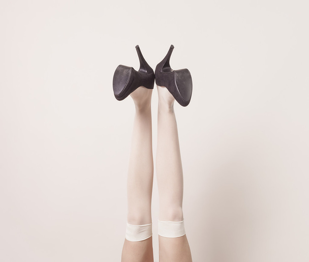 Female legs up in the air wearing heels and posing - Фото, изображение