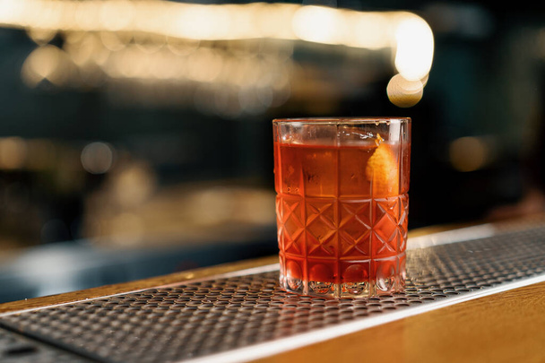 Hazır ve nefis alkollü kokteylin yakın çekimi Negroni barda duruyor ve misafirini bekliyor. - Fotoğraf, Görsel