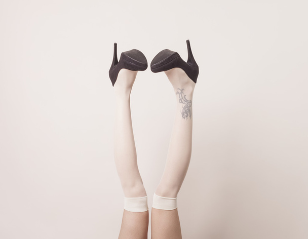 Female legs up in the air wearing heels - Foto, imagen