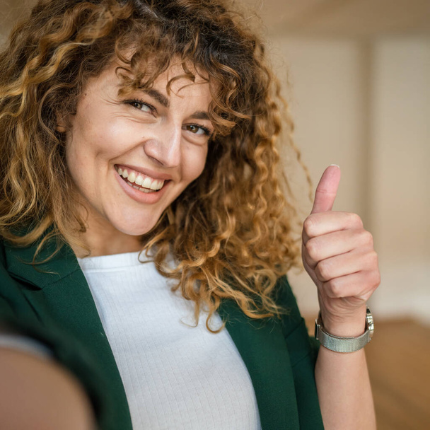 Μια γυναίκα καυκάσιος γυναίκα ευτυχής αυτοπεποίθηση σταθεί εσωτερικό στο καφέ με σγουρά μαλλιά χαμόγελο πραγματικό πρόσωπο αντίγραφο χώρο αυτο πορτρέτο selfie UGC User Generated Content - Φωτογραφία, εικόνα