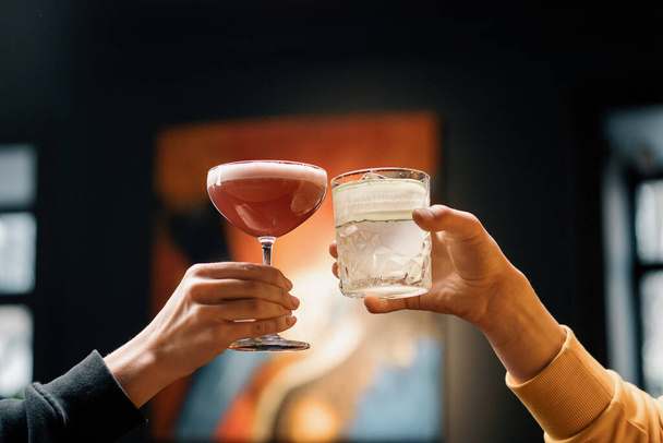 Close up of two people cheering cocktails in bar or disco club drinks and cocktails concept - Foto, immagini