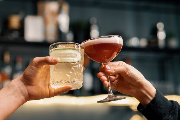 Nahaufnahme von zwei Menschen, die Cocktails in Bar oder Disco-Club-Drinks und Cocktails bejubeln - Foto, Bild