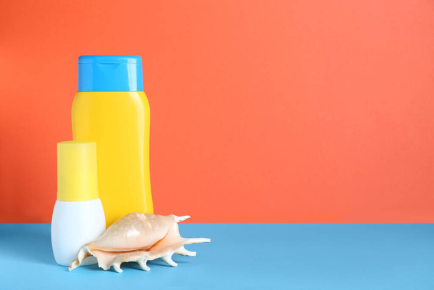 異なる日焼け製品と色の背景に貝殻。テキストのスペース - 写真・画像