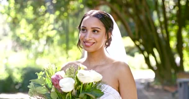 Gelukkige bruid, denken en bloemenboeket buiten voor viering in tuin, zomer en huwelijk. Vrouw, glimlach en dagdroom op trouwdag met rozen, bloemen en opgewonden om getrouwde toekomst te vieren. - Video