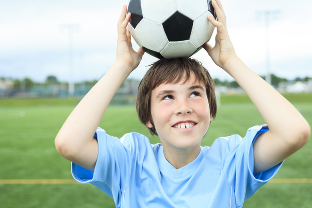 フィールド上のボールを持って若いサッカー選手 - 写真・画像