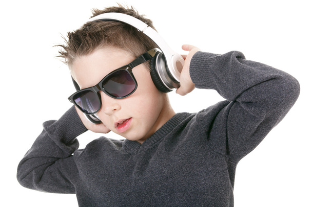 Young boy wearing headphones listening music in studio. - Foto, imagen