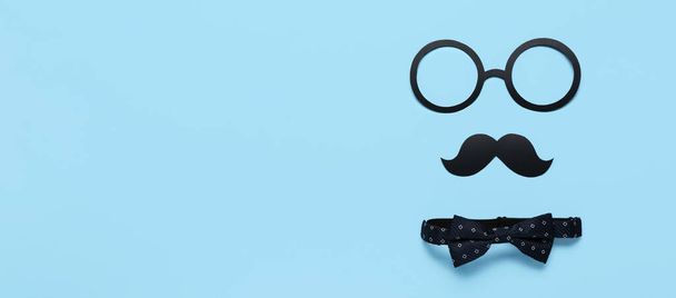 Composition with paper mustache, glasses and bowtie on light blue background with space for text. Father's Day celebration - Photo, Image