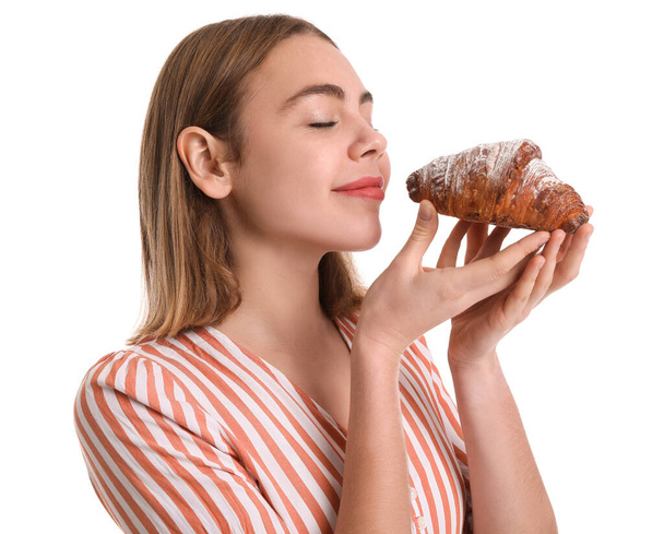 Female baker with tasty croissant on white background, closeup - Zdjęcie, obraz