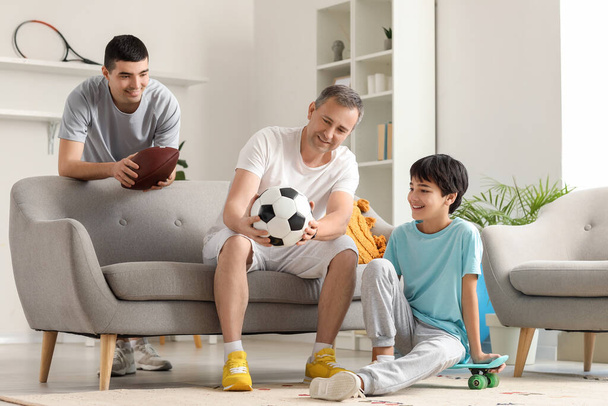 Sporty little boy with his dad and grandfather at home - Foto, afbeelding