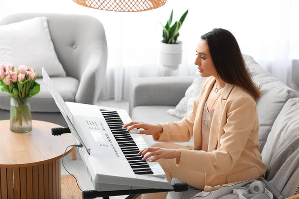 Młoda kobieta muzyk gra syntezatora w domu - Zdjęcie, obraz