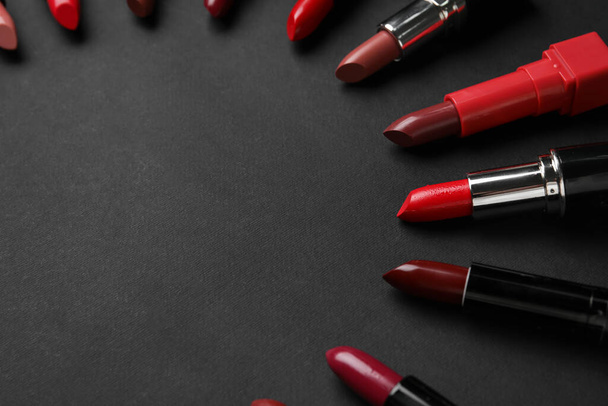 Composición con hermosos lápices labiales sobre fondo oscuro - Foto, imagen