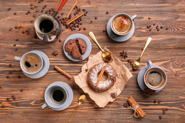 Cups of coffee with tasty pastry on wooden background - Photo, Image