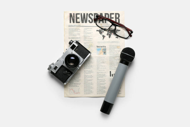 Gazeta z mikrofonem, aparatem fotograficznym i okularami na białym tle - Zdjęcie, obraz