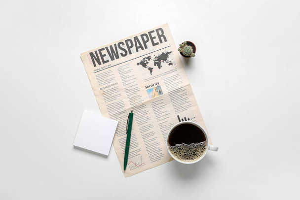 Giornale con tazza di caffè, note adesive, penna e cactus su sfondo bianco - Foto, immagini
