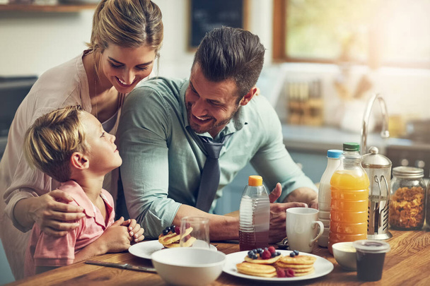 Las mejores mamás hacen panqueques para el desayuno. un niño desayunando con sus padres - Foto, Imagen