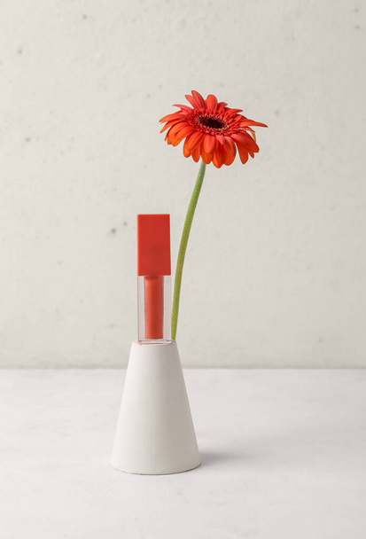 Dekoratív vakolat dobogó fényes és gerbera virág fehér asztalon - Fotó, kép