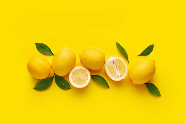 Composition with fresh lemons on yellow background - Фото, изображение