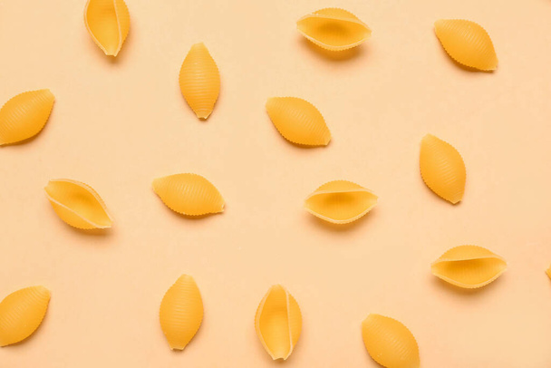Raw conchiglie pasta on yellow background - Fotó, kép