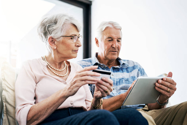 Dołączam do świata zakupów internetowych. para seniorów dokonująca płatności kartą kredytową na tablecie cyfrowym w domu - Zdjęcie, obraz