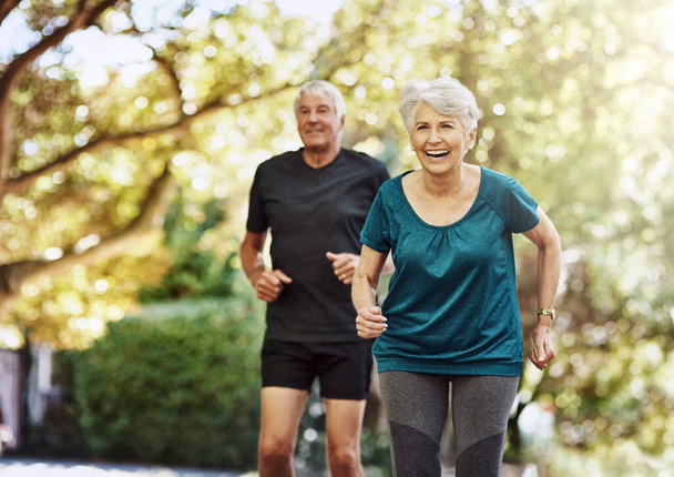 Come on, keep up. a senior couple out for a run together - 写真・画像