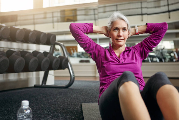 Exercising holds a lot of transformative power. a mature woman working out at the gym - Фото, зображення