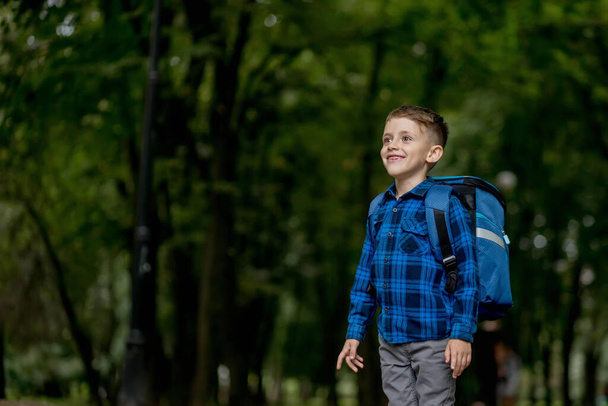 Portrait of a first grader with a backpack. The boy goes to school. - Foto, imagen