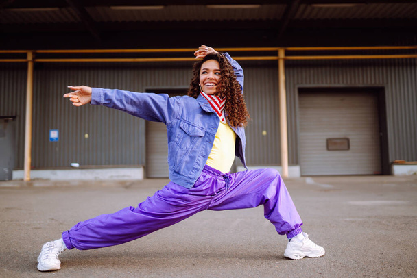 Stylish street dancer with American bandana is dancing. A young dancer in stylish clothes shows the movements. The concept of dance and sports. - Foto, afbeelding