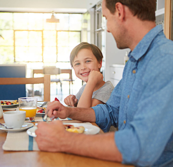 Сніданок має життєво важливе значення для дорослих дітей. молодий хлопчик насолоджується сніданком з батьком
 - Фото, зображення