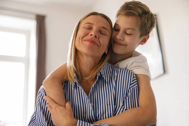 Cheerful son hugging happy mom with love and tenderness. Family, motherhood concept  - Valokuva, kuva