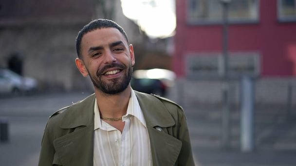 Ένας ευτυχισμένος Άραβας προχωράει προς την κάμερα. Εντοπισμός πυροβόλησε σε κίνηση ενός άνδρα της Μέσης Ανατολής χαμογελώντας και νιώθοντας αυτοπεποίθηση - Φωτογραφία, εικόνα
