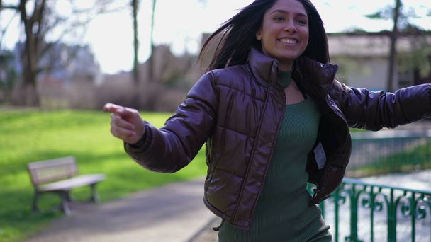 Egy gondtalan fiatal nő örömöt érez, miközben táncol a parkban, és a sikert ünnepli. Boldogság fogalma egy felnőtt lány a 20-as években ugrál fel-le érzés eksztatikus - Fotó, kép