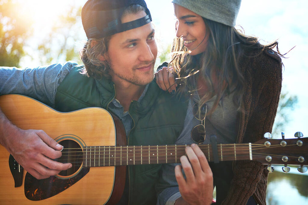 Tu amor es como música para mis oídos. un joven tocando a su novia una canción en su guitarra - Foto, Imagen
