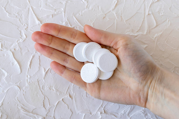Fizzy solúvel grande rodada suplementos vitamínicos você mulheres mão, close-up. - Foto, Imagem
