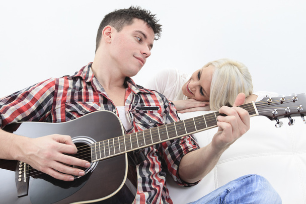 A handsome man playing guitar to a cute girl - Foto, Imagem
