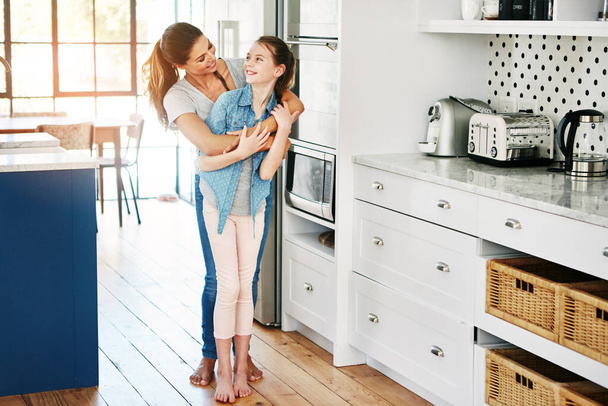 Creating and keeping a close connection with her daughter. a happy mother and daughter in a loving embrace at home - Foto, imagen