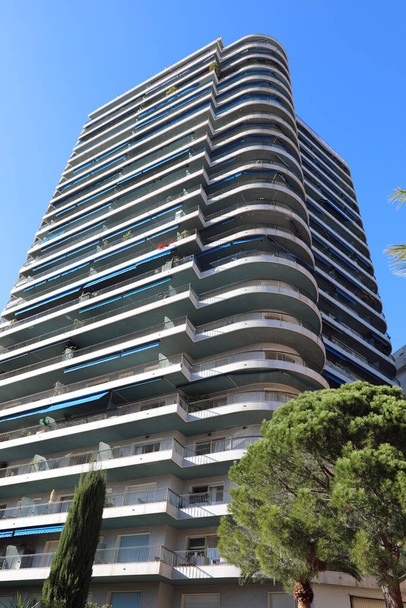 A feltűnően alacsony látószögű kilátás egy 20 emeletes lakóépület Monte-Carlo, Monaco, mely lekerekített erkélyek és kék napellenzők, bemutatja a 70-80-as évek építészete - Fotó, kép